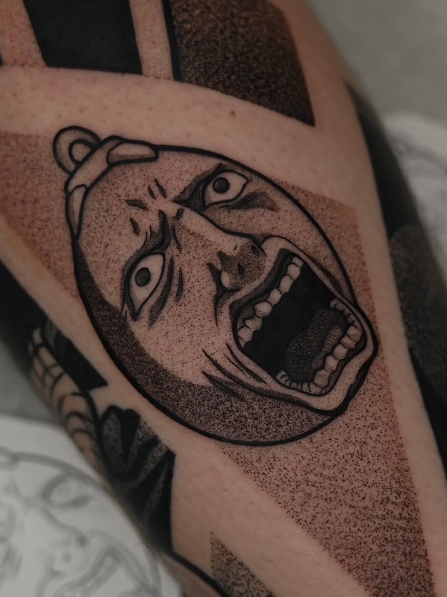 Behelit tattoo, Berserk bold blackwork design with wide grin in geometric frame by Wade Whitman — Madison Heights MI tattoo artist