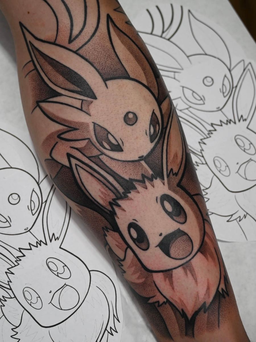 Eevee and Espeon tattoo, Pokemon creature family in orange and brown tones by Wade Whitman — Madison Heights MI tattoo artist