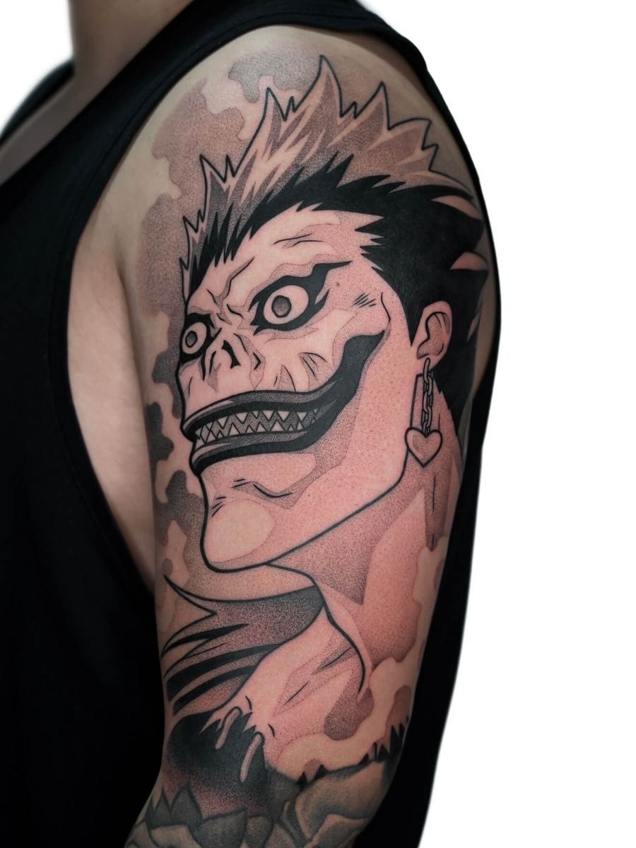 Ryuk tattoo, Death Note character bicep portrait with wide grin and sharp teeth by Wade Whitman — Madison Heights MI tattoo artist